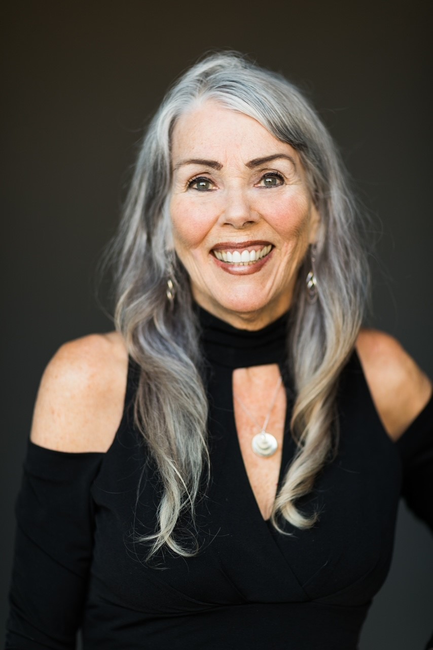 An older smiling woman with pretty silver hair